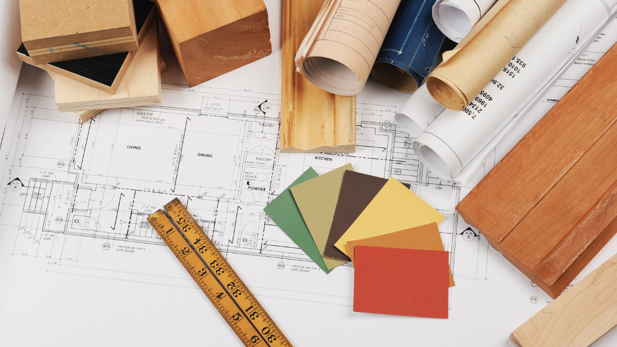 Architectural plans, wood building materials, and color swatches for commercial renovation planning.